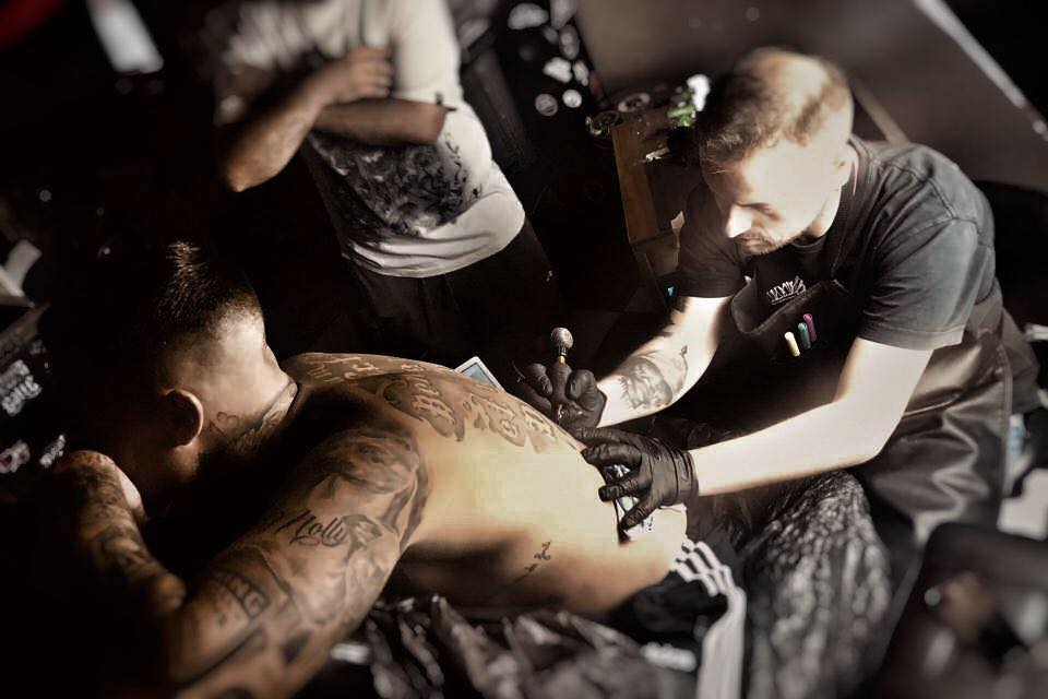 Miguele Tattoo realizando un tatuaje en una espalda en Black&Grey