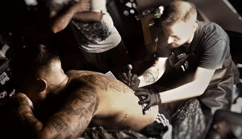 Miguele Tattoo realizando un tatuaje en una espalda en Black&Grey